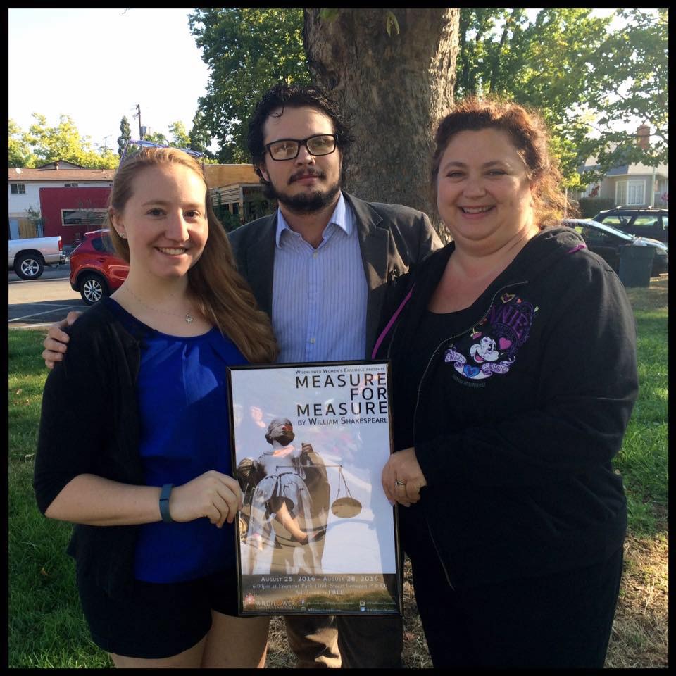 Three people holding a poster for Measure for Measure