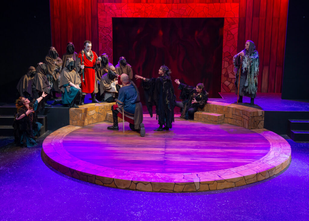The witches and banquo on a stage for Macbeth